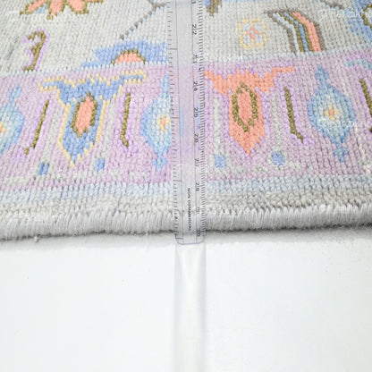Cross-stitched fabric with colorful designs and a ruler for scale on a white background