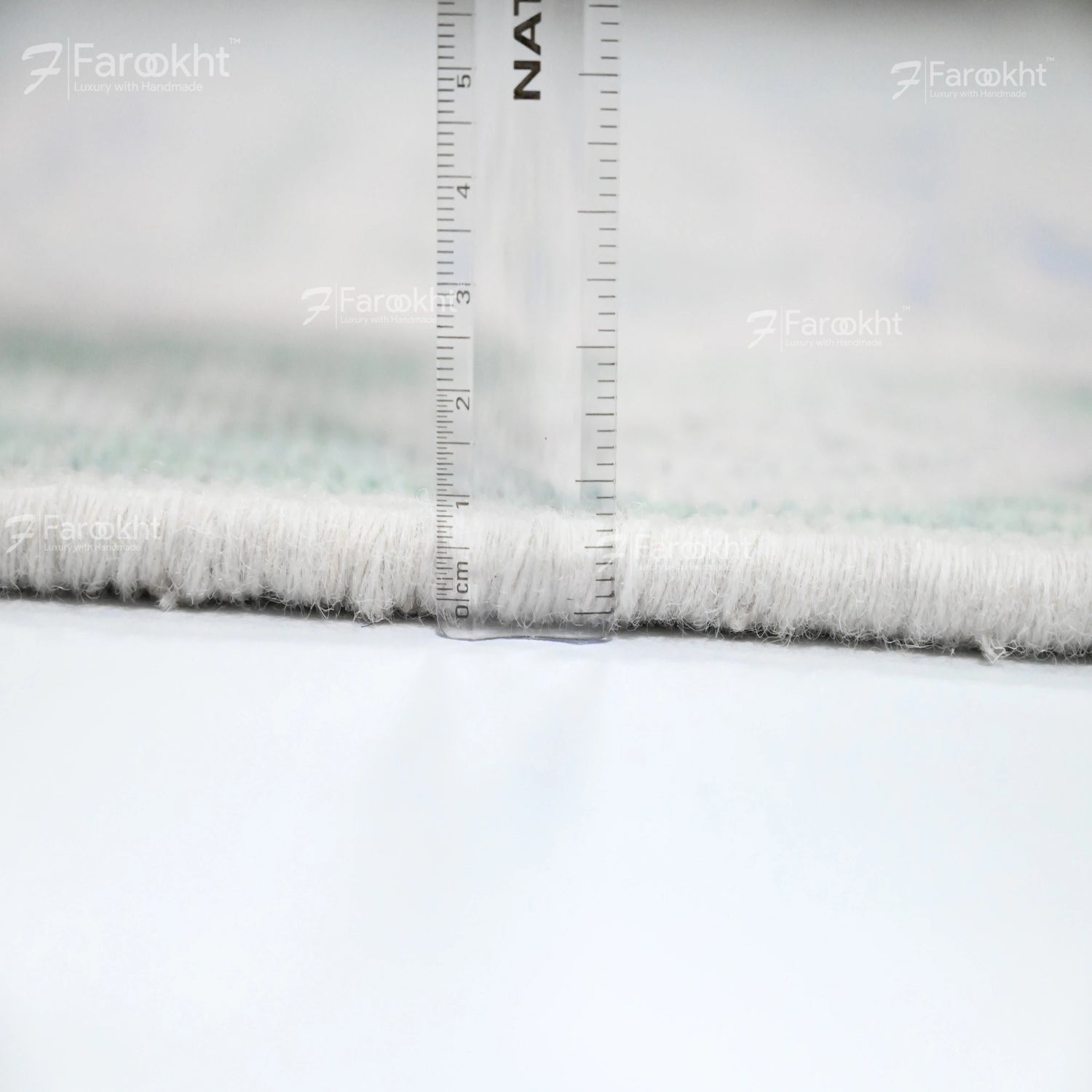 Close-up of fabric with a ruler for scale, branded &