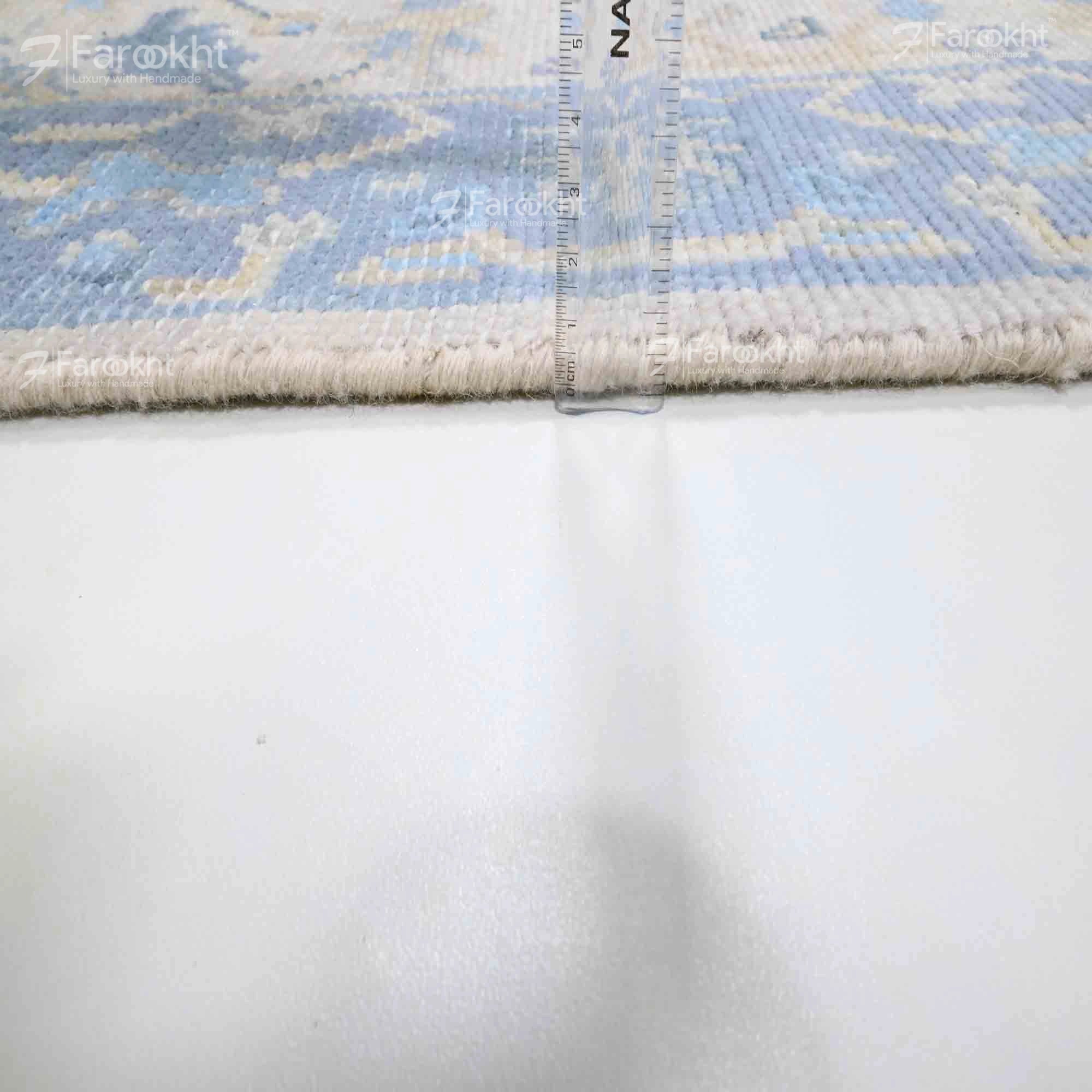 Rug with a geometric pattern on a white background, featuring the brand &