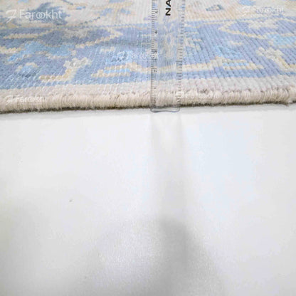 Rug with a geometric pattern on a white background, featuring the brand &
