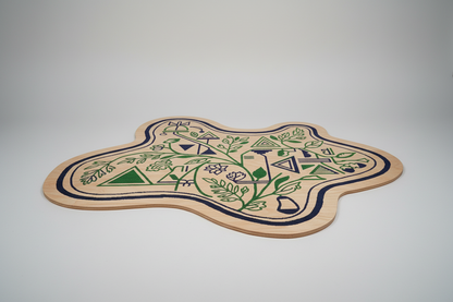 Irregular shaped hand-tufted rug with green floral and geometric patterns on a beige base.